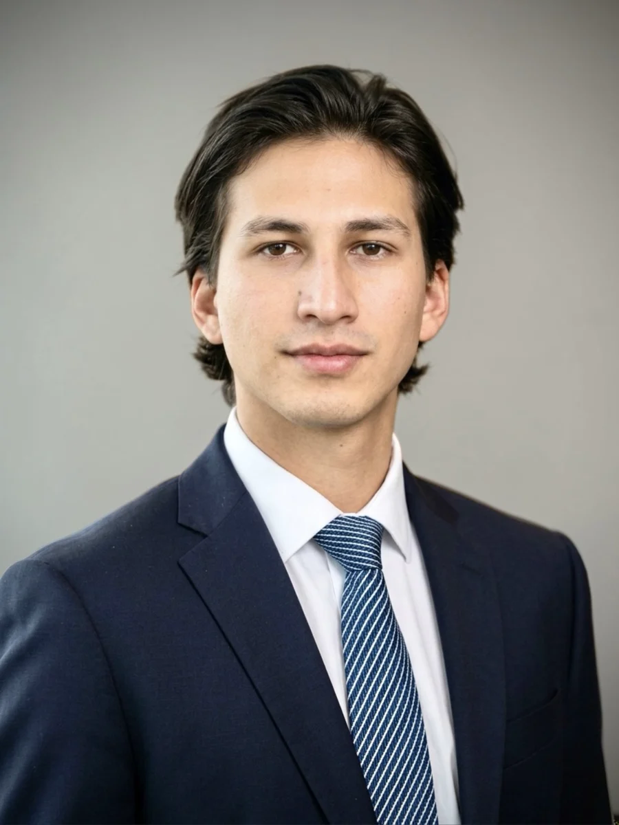 Portrait of Juan Diego Mogollon in a navy suit and striped tie